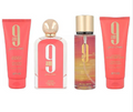 A 4-piece Annan 9am Jolie Femme fragrance set on a white background, including a coral pink body wash tube, a clear glass perfume bottle with a gold cap, a clear glass body spray bottle with a gold cap showing a sunset gradient, and a coral pink body lotion tube.