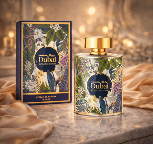 A perfume bottle and its matching box labeled 'Palm Dubai Extrait de Parfum' are displayed on a marble surface with draped satin fabric and warm bokeh lights in the background.