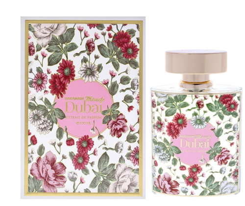 A perfume bottle and its matching box, both decorated with a colorful floral pattern featuring red, pink, and white flowers with green leaves on a white background. The box has a gold border and a pink circular label reading 'LUMIÈRE Dubai', and the bottle has a matching pink label and a pale pink cap.