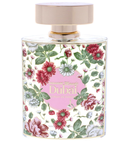 A bottle of Al Haramain Miracle Dubai Extrait de Parfum Spray, featuring a white background decorated with red, pink, and white flowers and green leaves, with a pink label and a beige cap.