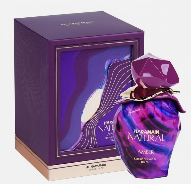Al Haramain Natural Amber Extrait de Parfum shown with its purple packaging box and the perfume bottle. The bottle features a faceted purple cap and a marbled purple and blue body with gold lettering.