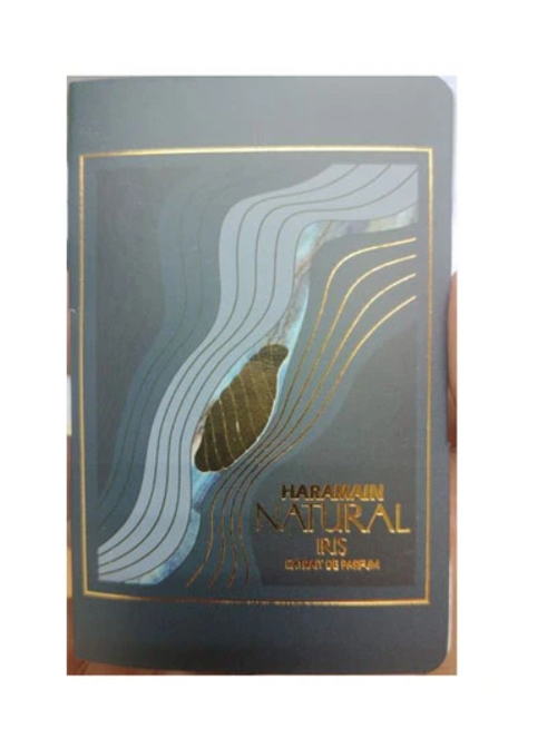 A rectangular perfume bottle or packaging box with a dark gray cover, featuring gold foil wave lines and the text 'HARAMAIN NATURAL IRIS ' in gold. 