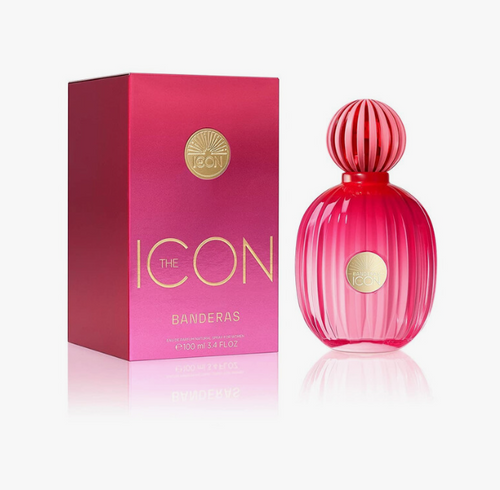 A pink ribbed perfume bottle with a matching pink box, both featuring gold lettering and a circular gold logo, photographed on a clean white background with a soft reflection below.