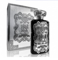 A black perfume bottle with ornate silver Arabic calligraphy and detailing, shown next to its matching silver decorative box on a white background.