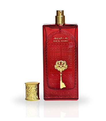 A red rectangular perfume bottle with a gold spray top and a matching gold key motif on the front, shown beside a small gold cylindrical cap on a white background.