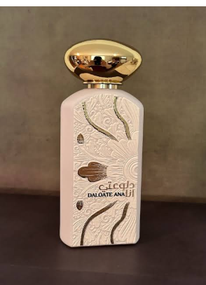A bottle of Dalante Ana Lil perfume with a textured cream-colored body, gold embossed patterns, and a shiny gold cap, set against a dark brown background.