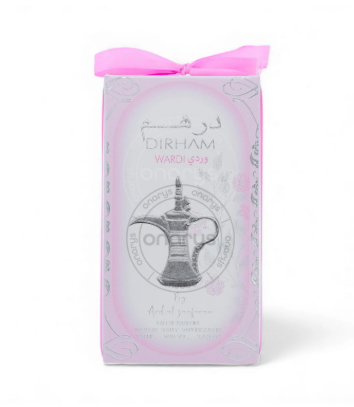 A boxed perfume product wrapped in a pale pink translucent sleeve with a bright pink ribbon bow at the top. The front shows the text 'DIRHAM' and 'WADI YASIN' with a silver teapot illustration in the center.