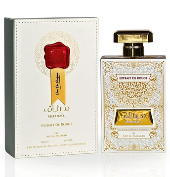 A bottle of Olio Meethiql 'Extrait De Rougi' perfume next to its ornate white and gold packaging box with a red wax seal graphic.