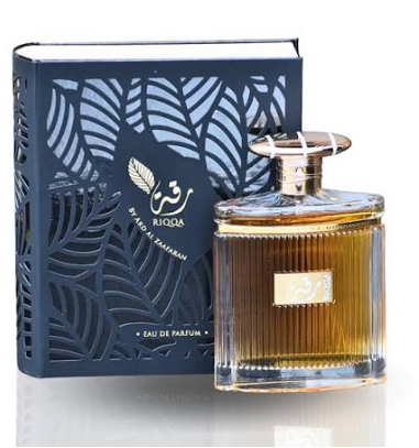 A bottle of Blouda Eau de Parfum with amber-colored liquid, shown next to its navy blue box with a laser-cut leaf pattern.