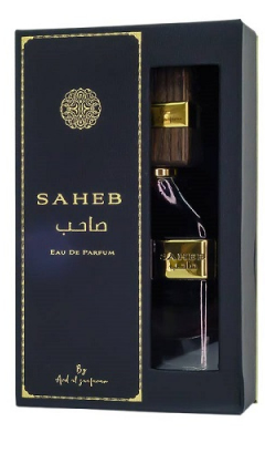 A clear glass perfume bottle with vertical ribbing, filled with golden amber liquid and topped with a gold cap. A gold label on the front features Arabic calligraphy and the brand name 'RICOQA'.