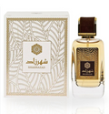 Shahrazad perfume bottle and its matching box, featuring a clear glass bottle filled with golden-amber liquid, a dark brown cap, and a white box with gold geometric patterns and Arabic script.