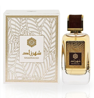 Shahrazad perfume bottle and its matching box, featuring a clear glass bottle filled with golden-amber liquid, a dark brown cap, and a white box with gold geometric patterns and Arabic script.