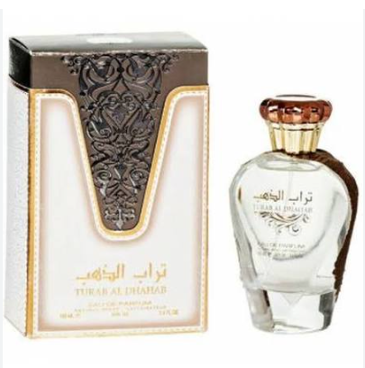 Turab Al Dhahab Eau de Parfum bottle and its ornate packaging box, featuring a clear glass bottle with a brown cap and a white and gold box with black detailing.