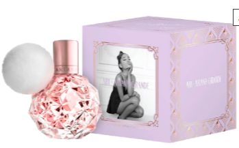 A pink faceted perfume bottle with a white fluffy pom-pom and a metallic pink cap, shown next to a lavender gift box with gold trim and a black-and-white photo of a woman on the front.