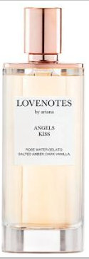 A bottle of Arianas Lovenotes Angels Kiss perfume, featuring a clear glass bottle with a pale amber liquid and a metallic rose gold cap.