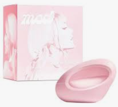A light pink silicone intimate accessory shown in front of its matching pink packaging box, which features a stylized illustration of a woman's face.