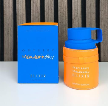Odyssey Mandarin Sky Elixir perfume bottle in a bright orange leatherette case with a blue cap, shown next to its blue and orange retail box on a white surface.