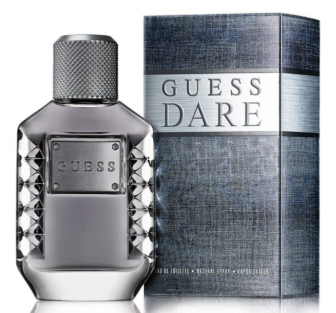Guess Dare Eau de Toilette bottle and packaging box. The bottle is a faceted metallic silver-gray glass with a textured cap, and the box features a blue-gray textured pattern with a silver band displaying the 'GUESS DARE' logo.