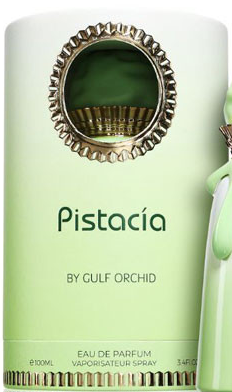 A cylindrical perfume packaging box labeled 'Pistacia BY GULF ORCHID' in pale mint green, with a decorative gold-toned oval medallion near the top and a matching pale green spray atomizer partially visible on the right.