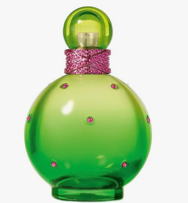 A green glass perfume bottle with a rounded body, a matching green spherical cap, and a pink rhinestone-embellished band around the neck, shown on a plain light gray background.