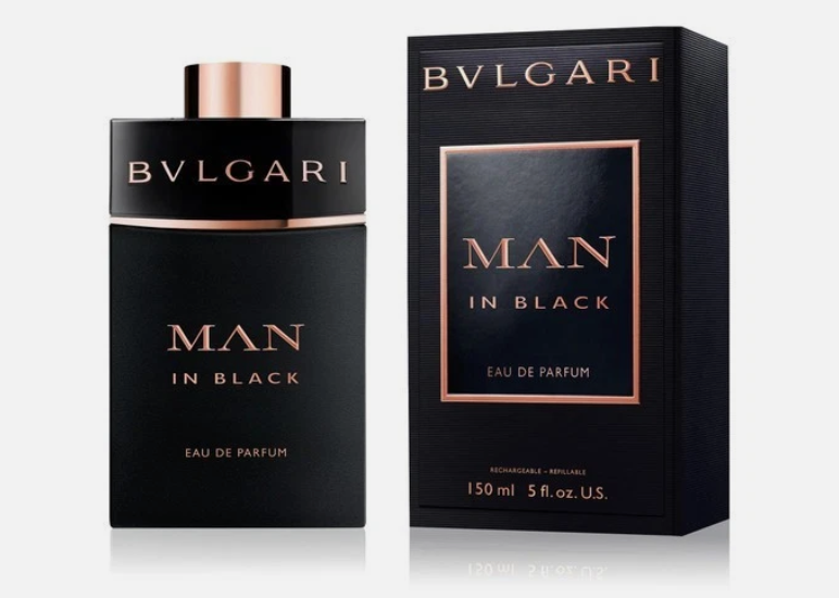 Bvlgari Man in Black Eau de Parfum bottle and its retail box, both in black with rose gold lettering and trim, on a light gray background.