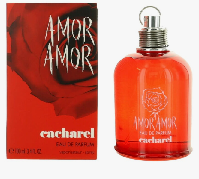 A bottle of Cacharel Amor Amor Eau de Parfum next to its red packaging box, featuring a red rose graphic and white text on a white background.