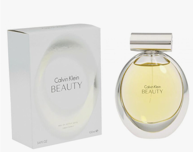 Calvin Klein Beauty Eau de Parfum 100ml bottle next to its white packaging box, featuring a clear spherical bottle with pale yellow liquid and a silver cap.