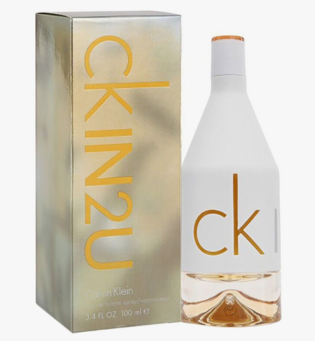 Calvin Klein CK in2u perfume bottle and matching metallic box on a white background. The bottle is frosted white with gold 'ck' lettering and a gold cap, while the box is metallic gold with large vertical 'kin2u' text.