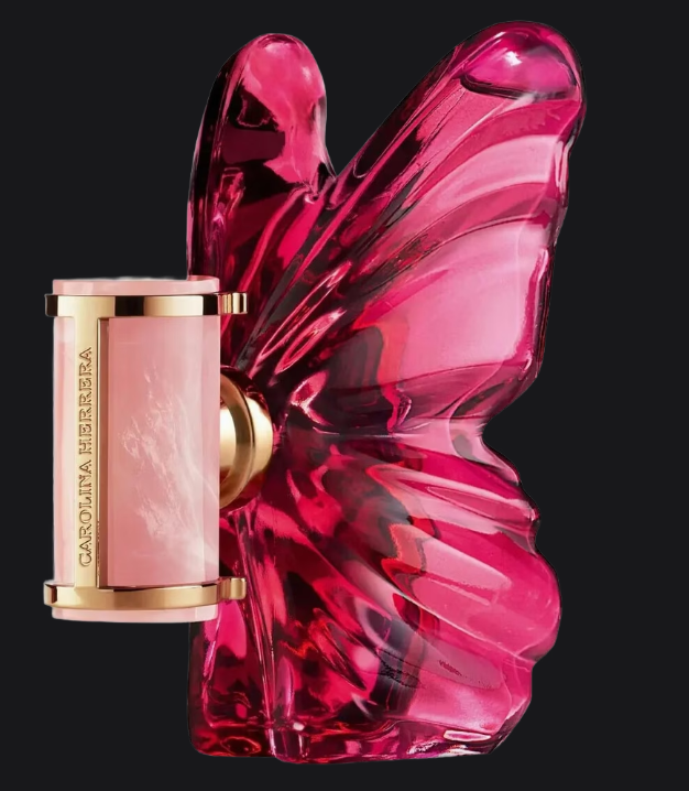Carolina Herrera Ladies La Bomba perfume bottle featuring a translucent pink butterfly wing design with a pink marble-look cylindrical base and gold-tone metal trim, shown against a solid black background.