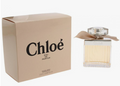 Chloé Eau de Parfum bottle with a beige ribbon bow next to its beige packaging box, on a white background.