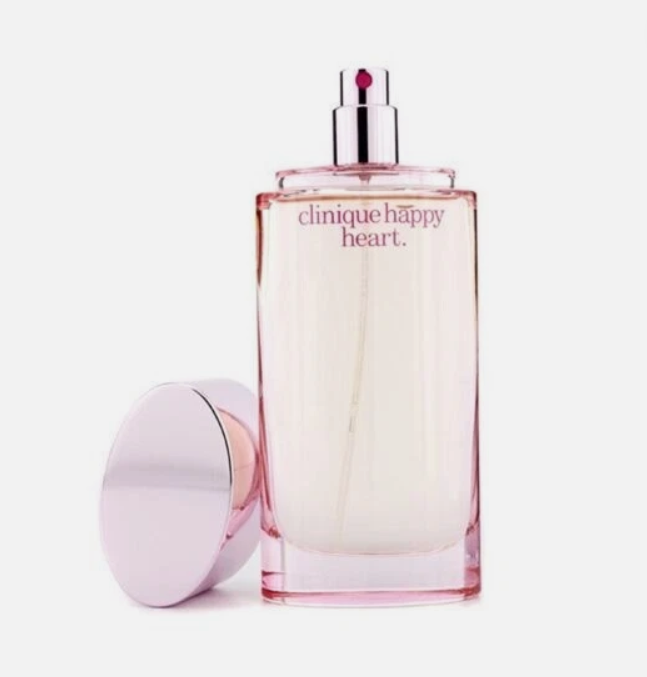 Clinique Happy Heart Eau de Parfum bottle in a pale pink glass with a silver spray top, shown next to its matching pink cap on a white background.
