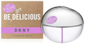 DKNY Be Delicious Eau de Parfum bottle and its brown cardboard packaging box. The bottle is a clear, rounded dome shape with a purple stripe, and the box is brown with white and purple branding.