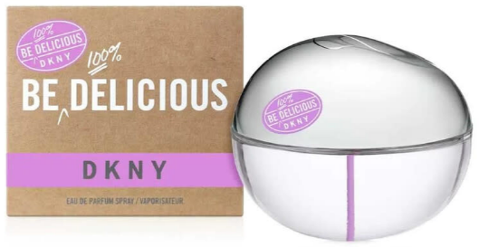 DKNY Be Delicious Eau de Parfum bottle and its brown cardboard packaging box. The bottle is a clear, rounded dome shape with a purple stripe, and the box is brown with white and purple branding.