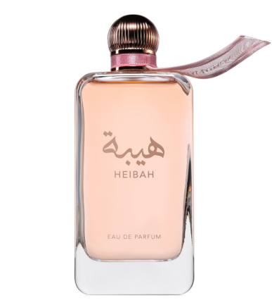 Heibah Eau de Parfum bottle with a rectangular clear glass body, light peach-pink liquid, a metallic rose gold cap, and a matching pink ribbon tag, shown on a white background.