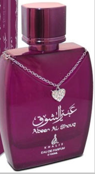 A bottle of Khafas Aben Al Shouq perfume in a deep magenta-purple color, featuring a silver heart-shaped pendant on a chain draped across the bottle, with Arabic and English text on the front.