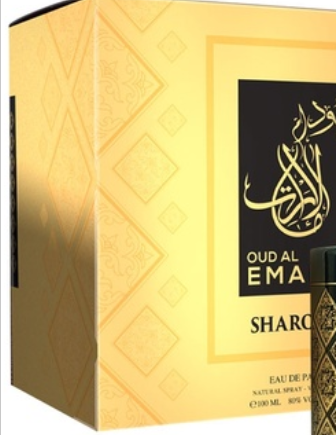 Oud Al Ema Sharq perfume packaging box in gold with a black label featuring Arabic calligraphy and the text 'OUD AL EMA SHARQ', alongside a small bottle shown at the lower right.