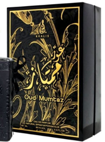A black rectangular perfume box with ornate gold Arabic calligraphy and floral motifs, alongside a matching black bottle, on a plain white background. The box prominently displays the text 'Oud Mumtz' and the brand name 'Khair'.