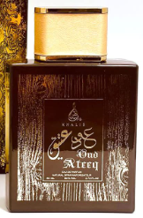A bottle of Rukus And Ateeq perfume oil with a dark brown wooden-textured bottle, a gold cap, and gold Arabic calligraphy on the front label.