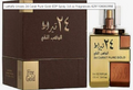 A perfume bottle and its box for Lattafa Unisex 24 Carat Pure Gold EDP Spray. The packaging is dark brown with gold lettering and accents, and the bottle itself is gold with a rose gold-toned cap.