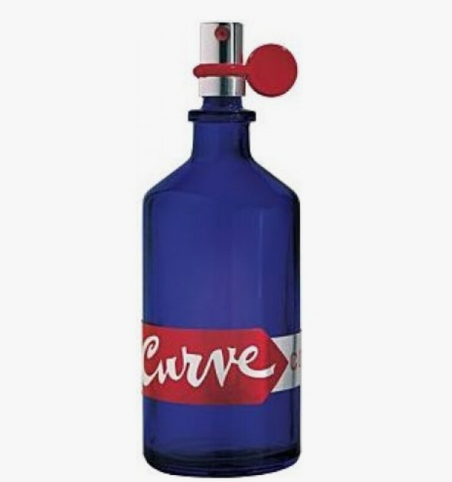 A cobalt blue glass perfume bottle with a red and white 'Curve' label and a red flip-top cap, shown against a plain white background.