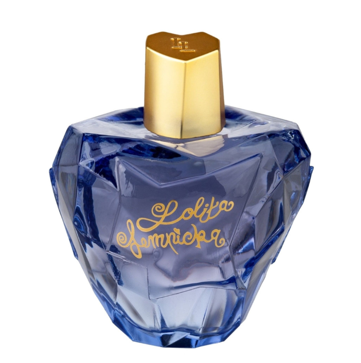 A faceted blue glass perfume bottle with a metallic gold cap and gold script lettering that reads 'Lolita Hammacka' on the front, isolated on a white background.