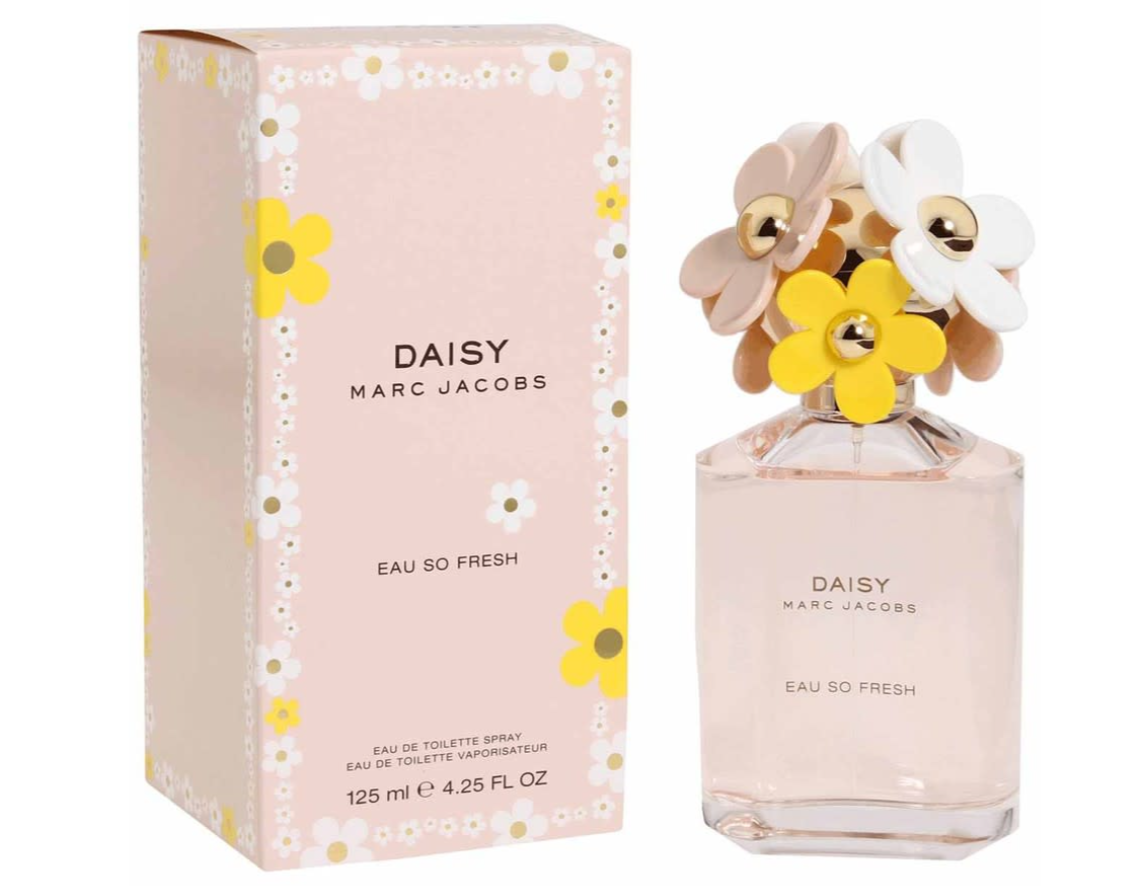 Marc Jacobs Daisy Eau So Fresh perfume bottle with a floral cap next to its pink floral-patterned box, on a white background.