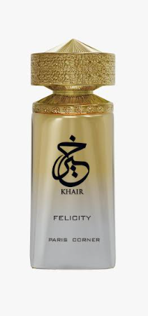 A perfume bottle labeled 'KHAIR FELICITY PARIS CORNER' with a gold cap and a frosted glass body that fades from gold at the top to white at the bottom, on a light gray background.