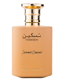 A bottle of TASKEEN Caramel Cascade perfume with a matte peach-beige body and a shiny gold cap, shown on a plain white background.