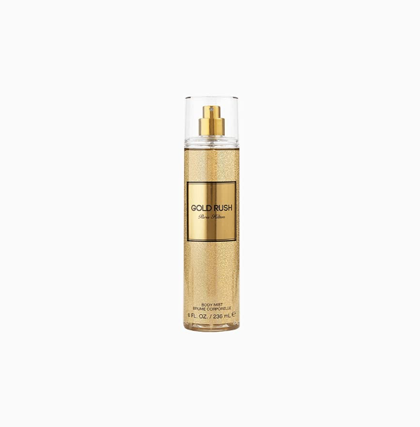 A bottle of Gold Rush body mist by Paris Hilton, featuring a textured gold finish and a gold label with black lettering, set against a plain white background.
