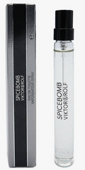 A clear glass perfume spray vial with a black spray top stands next to its black and silver rectangular box. The product label reads 'SPICEBOMB VIKTOR&ROLF'.