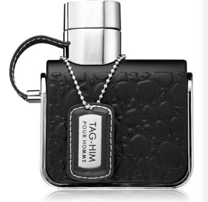 TAG-HIM Pour Homme fragrance bottle in black textured glass with a silver cap, a black leather loop, and a silver dog tag pendant on a white background.