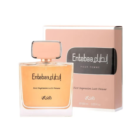 Entebaa Pour Femme perfume bottle and its packaging box. The bottle contains a warm peach-colored liquid and features a square cap with a metallic silver border.
