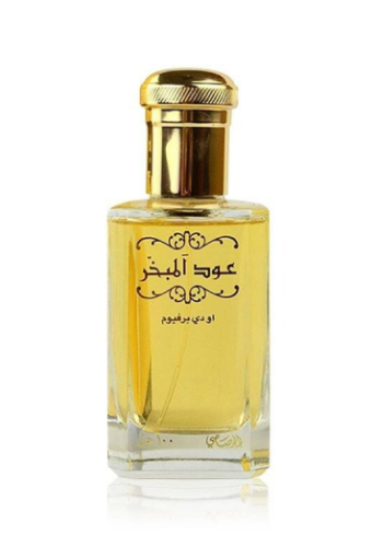 A rectangular glass perfume bottle filled with golden-yellow liquid, featuring a shiny gold cap and black Arabic lettering on the front, set against a plain white background with a soft reflection below.