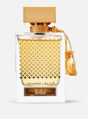 A bottle of Qasamat Bareez perfume with a textured gold patterned glass body, a gold cap, and a white base with a gold label and tassel.